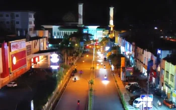 Pemandangan lanskap malam hari Masjid Raya Al-Munawwar Kota Ternate dengan lampu kota yang tenang sebagai latar berita pemberlakuan jam malam bagi anak dan remaja tahun 2026.
