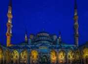 Ilustrasi masjid dengan kubah bercahaya di bawah langit malam bertabur bintang untuk menyambut awal Ramadhan 1447 Hijriah.